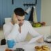 Man sitting at table reading papers with breakfast
