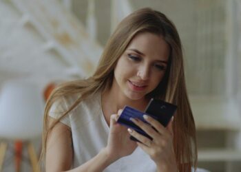Young woman holding credit card and smartphone