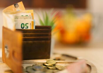 A wallet sitting on top of a table filled with money