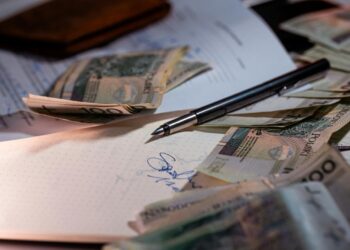 Pen and money scattered on documents
